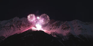 Feuerwerk über schneebedeckten Bergen