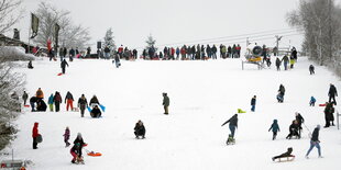 Viele Leute auf einem mit Schnee bedeckten Hang