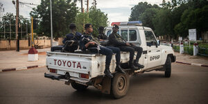 Bewaffnete Polizisten sitzen auf der Ladefläche eines Toyata-Pickups.