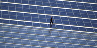Ein Techniker läuft über das Dach des Alpincenters in Wittenburg, auf dem eine Photovoltaik-Anlage montiert wurde.