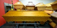 Dutzend Holzsärge stapeln sich in einem Krematorium