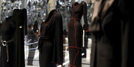 Schwarze Kleider-Kreationen berühmter Desinger/innen werden in einem Museum gezeigt