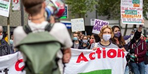 Viele Menschen mit Transparenzen demonstieren auf der Straße für Klimaschutz