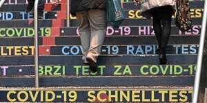 Auf den Stufen einer Treppe in der Corona-Teststation im Austria Center steht in verschiedenen Sprachen "Covid-19 Schnelltest"