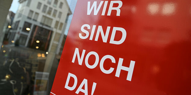Friedrichshafen: Ein Taschenladen weist mit einem Schild auf seinen Onlineshop hin. Auf dem Schild steht: "Wir sind noch da!". Im Kampf gegen die Corona-Pandemie hat am 16.12.2020 um 0.00 Uhr ein harter Lockdown in Deutschland begonnen. Bundesweit muss de