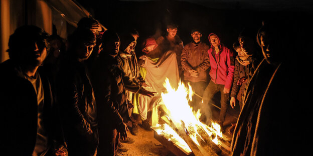 Migranten wärmen sich an einem Feuer im Flüchtlingscamp Lipa