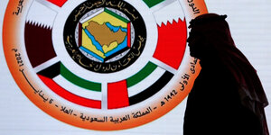 Ein saudischer Fernsehmoderator steht vor dem Logo des 41. Golf-Kooperationsrates (GCC) im Medienzentrum
