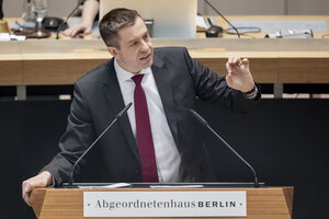 Ein Mann steht am Rednerpult des Parlaments Ein Mann steht am Rednerpult des Parlaments