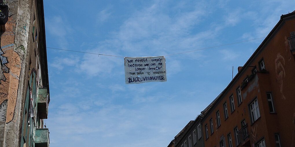 Ein solidarischer Gruß an die Black Lives Matter-Bewegung steht auf einem Banner, das zwischen zwei Häuser gespannt ist