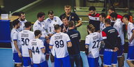 Russische Handballteam sammelt sich bei Besprechung um den Trainer