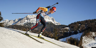 Eine Biathletin fährt den Hang hinunter