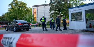 Hinter dem Flatterband stehen mehrere Polizeibeamte im abgesperrten Bereich vor der Hamburger Synagoge