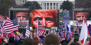 Trump Anhänger mit Flaggen der Vereinigten Staaten schauen auf Video-Leinwände