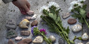 Bemalte Steine werden niedergelegt am Fuß eines Granit-Holocaust-Überlebenden-Denkmals