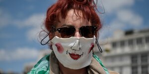 Eine Frau trägt eine mit einem Mund und Nase selbstbemalte Maske