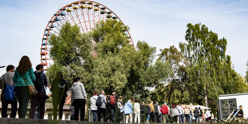 menschen stehen vor dem Riesenrad