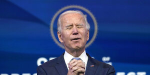 Joe Biden schließt die Augen und hält die Hände zum Gebet