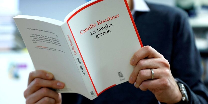 Ein Mann liest das Buch "La Familia Grande"