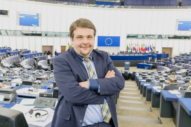 Dennis Radtke steht mit verschränkten Armen im Plenarsaal des Europäischen Parlaments