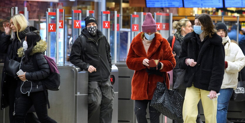 Menschen laufen mit wenig Abstand durch einen Bahnhof in Stockholm