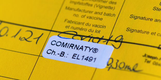 Ausschnitt Impfpass mit Aufkleber der Coronaimpfung und handscchriftlichem Datum