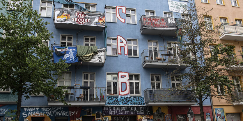 An der Fassade eines linken Hausprojekts hängen Transparente