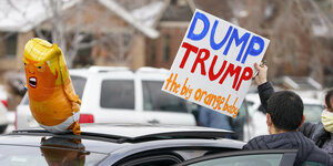 gelber Trump Ballon und Schild "Dump trump the big yellow baby"