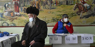 Ein älterer und ein jüngerer Mann in einem Wahllokal in Kirgistan