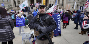 Ein Mann trägt ein Gewehr während einer Kundgebung vor dem kapitol in Washington
