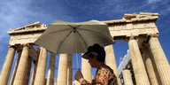 Tourist mit Schirm vor der Akropolis