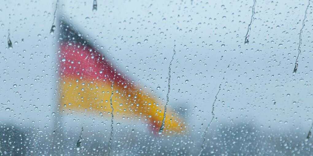 Eine schwarz-rot-goldene Flagge weht im Regen