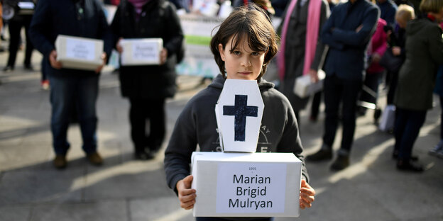 Trauerzug in Dublin zum Gedenken an die toten Kinder des Tuam Mother and Baby Home - Ein Mädchen hält eine Bestattungskiste in den Händen