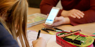 Ein Kind macht an seinem Schreibtisch Schulaufgaben.