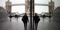 Frau läuft Richtung Tower Bridge in London und spiegelt sich in einem Fenster