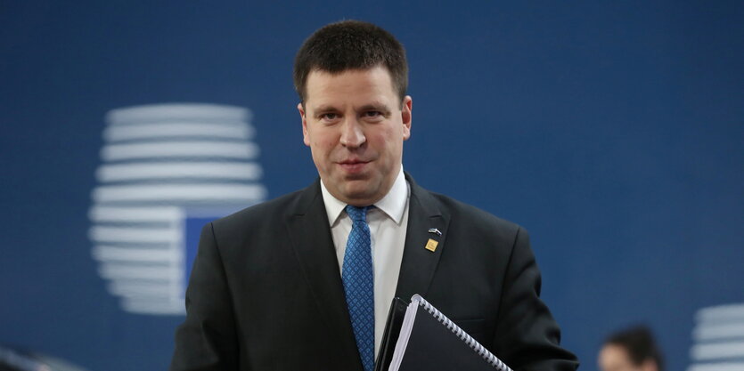 Jüri Ratas mit Unterlagen im Arm.