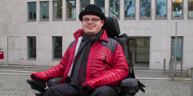 Constantin Grosch im Rollstuh sitzend vor einem Gebäude