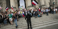 Rechtsextreme auf den Stufen des Reichstags, davor ein Polizist