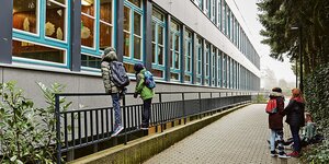 Schüler beobachten vor einem Hamburger Gymnasium ihre Klassenkameraden durch das Fenster