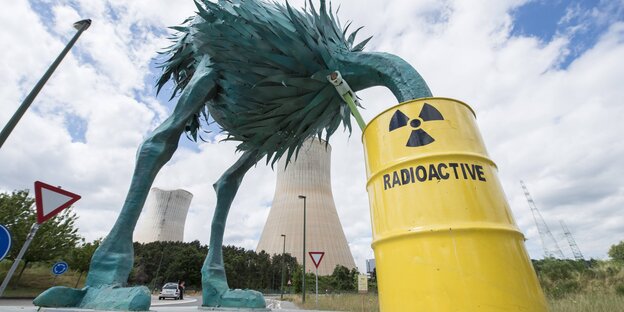 Protestaktion vor dem Atomkraftwerk Tihange in Belgien - eine Strauß-Figur Steckt den Kopf in ein Fass mit der Aufschrift "Radioactive"