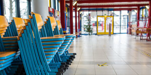 Gestapelte Stühle stehen im Eingangsbereich einer Realschule