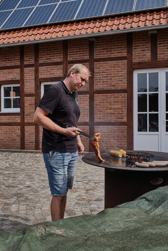 Ein mann hält eine Stück Fleisch mit einer grillzange