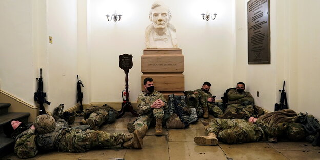 Mitglieder der National Guard schlafen im Capitol vor einer Lincoln-Büste im Capitol