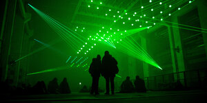Menschen stehen vor einer grünen Lichtinstallation