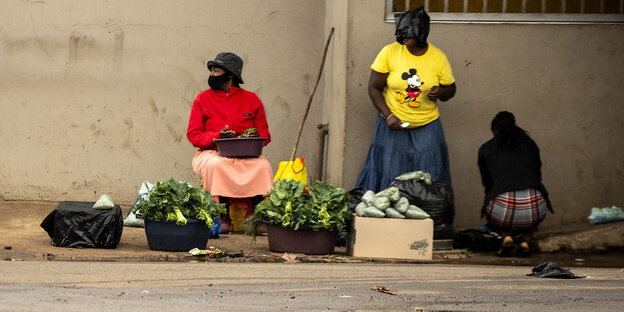 Strassenverkäuferinnen in Südafrika mit Gesichtsmaske, eine Frau trägt eine Plastiktüte über dem Kopf