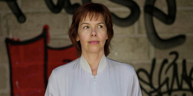 Autorin Julia Deckt in Trainingsjacke vor Graffiti-Wand