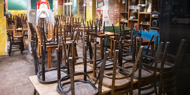 Stühle stehen umgedreht auf Restauranttischen