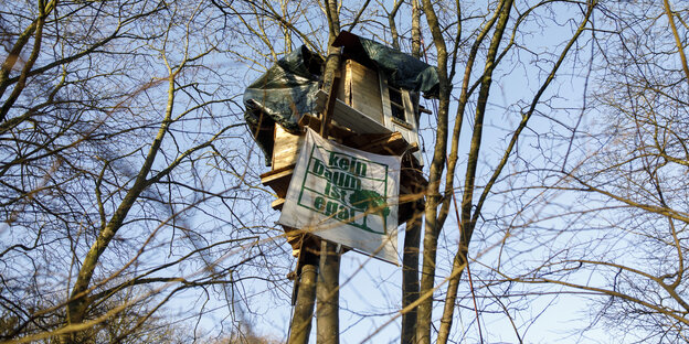 Baumhaus mit Transparent: "Kein Baum ist egal"