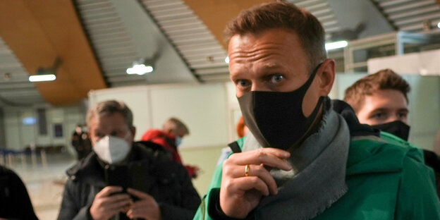 Nawalny bei der Passkontrolle in Moskau am Flughafen. Er trägt eine Maske.