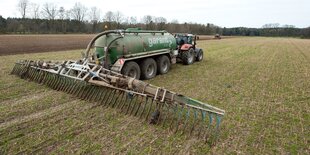 Ein Feld wird mit einer großen Landmaschine gedüngt