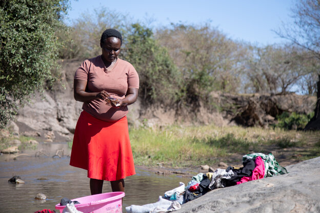 Eine Frau beim Wäschewaschen am Fluss